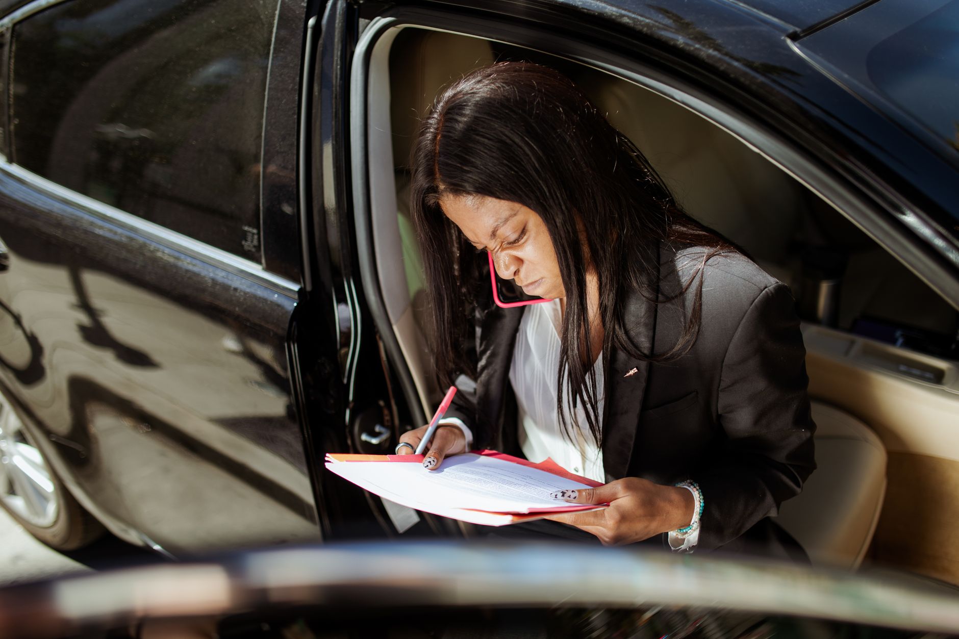 Mulher assinando um documento dentro do carro